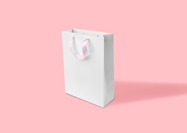 Image of White paper bag on pink background. Mockup for design