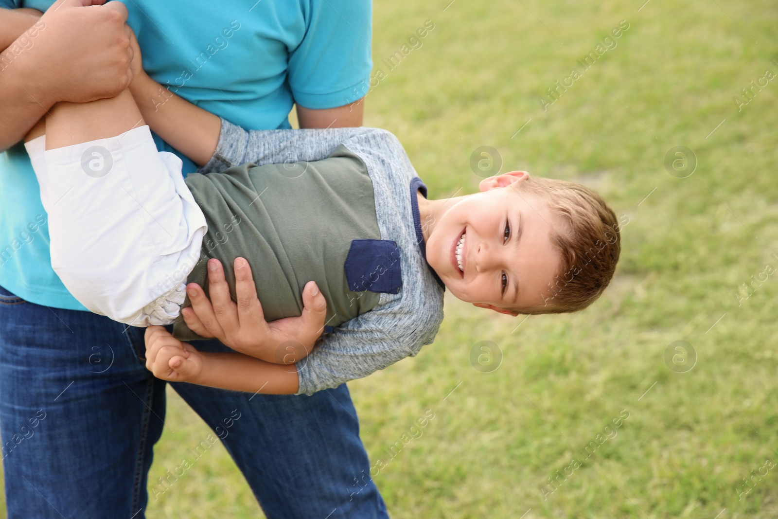 Photo of Man playing with his child outdoors. Happy family