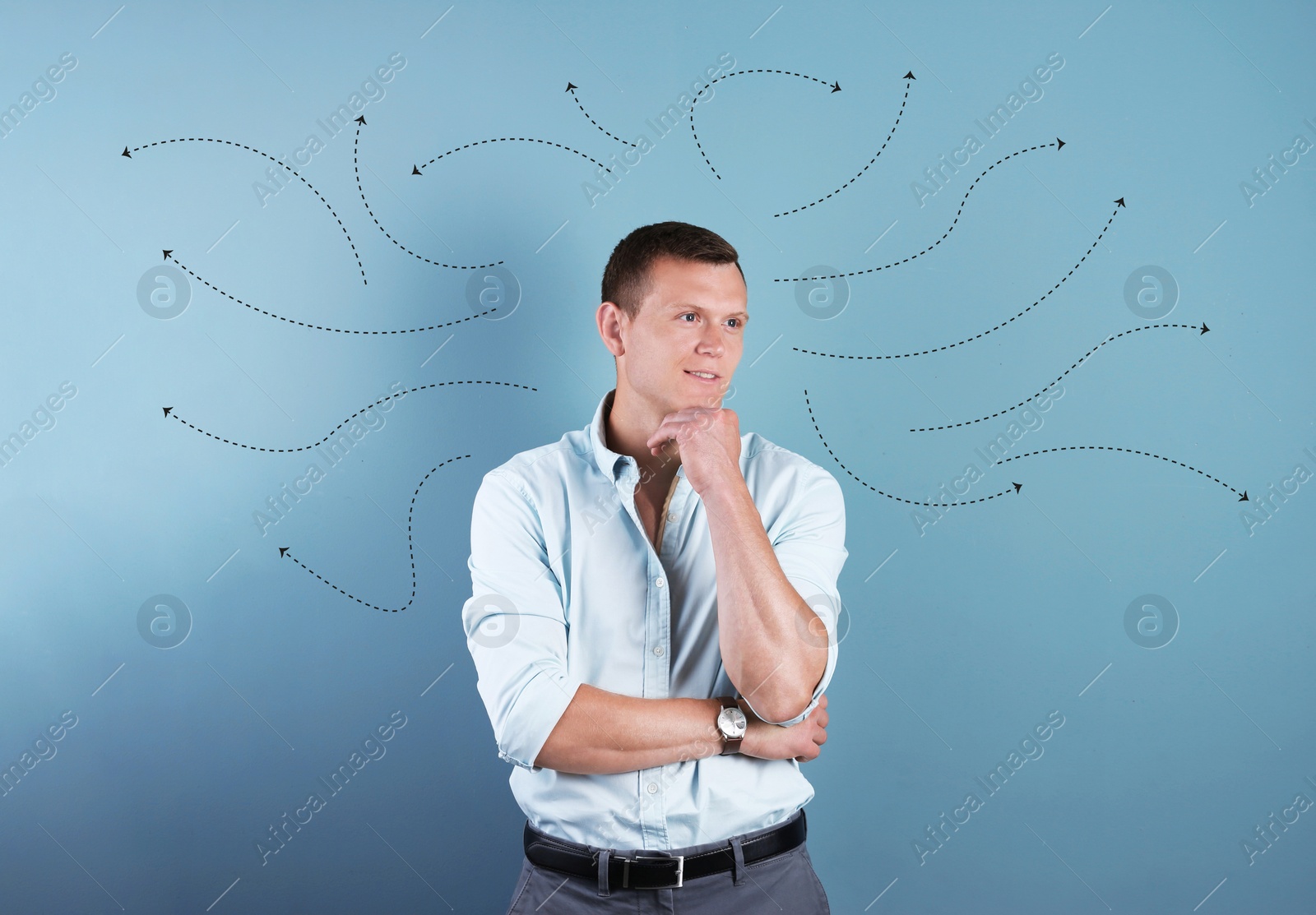 Image of Choice in profession or other areas of life, concept. Making decision, thoughtful young man surrounded by drawn arrows on color background