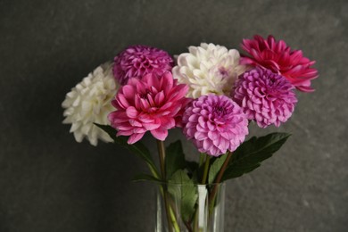 Photo of Bouquet of beautiful Dahlia flowers near dark grey wall, closeup