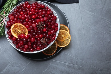 Flat lay composition with fresh ripe cranberries on grey table. Space for text