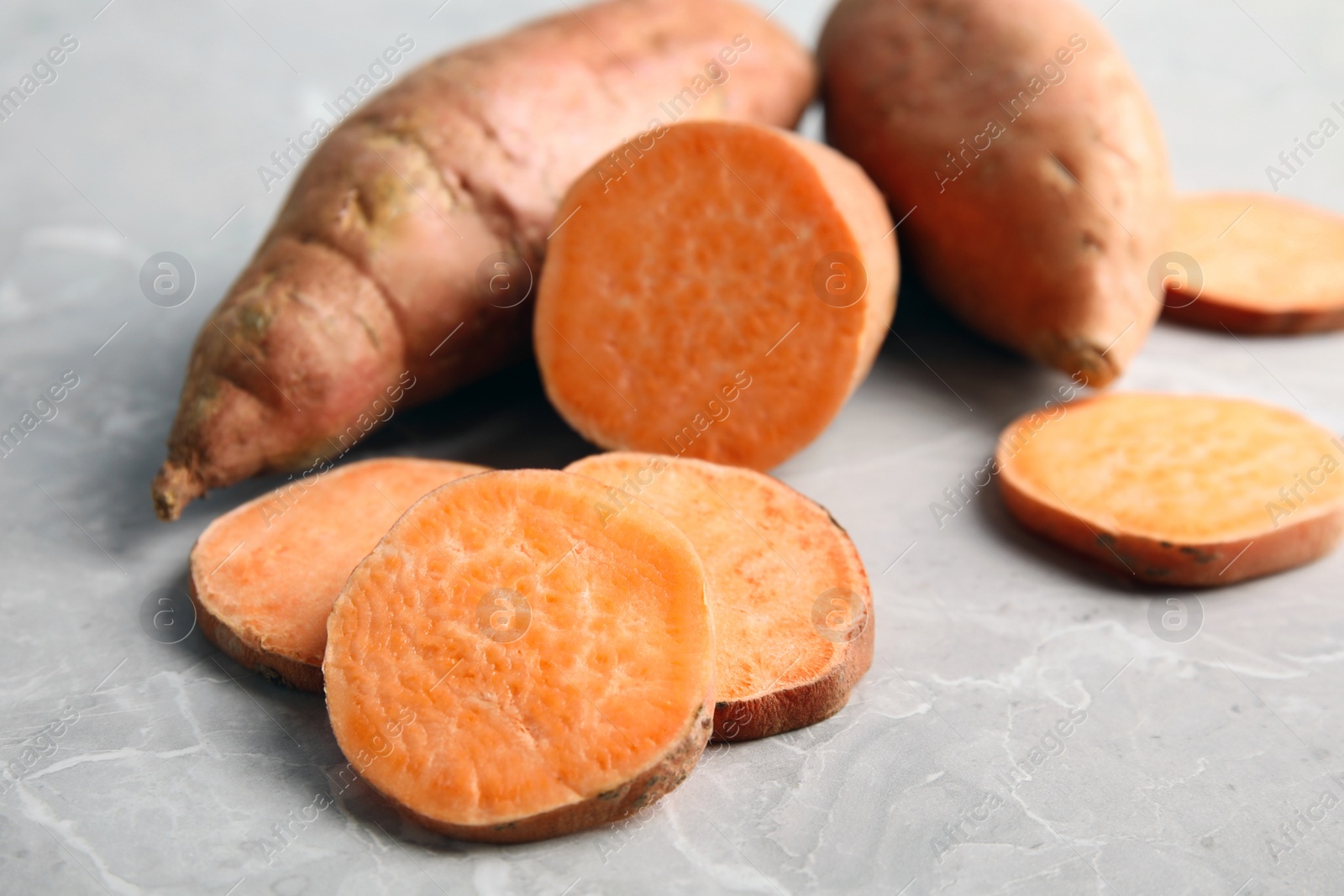 Photo of Composition with sweet potatoes on grey background