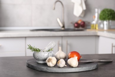 Photo of Fresh raw garlic, onion and rosemary on grey table