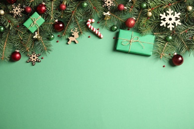 Photo of Fir tree branches with Christmas decoration on green background, flat lay. Space for text