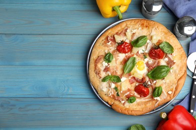 Photo of Delicious homemade pita pizza and ingredients on light blue wooden table, flat lay. Space for text