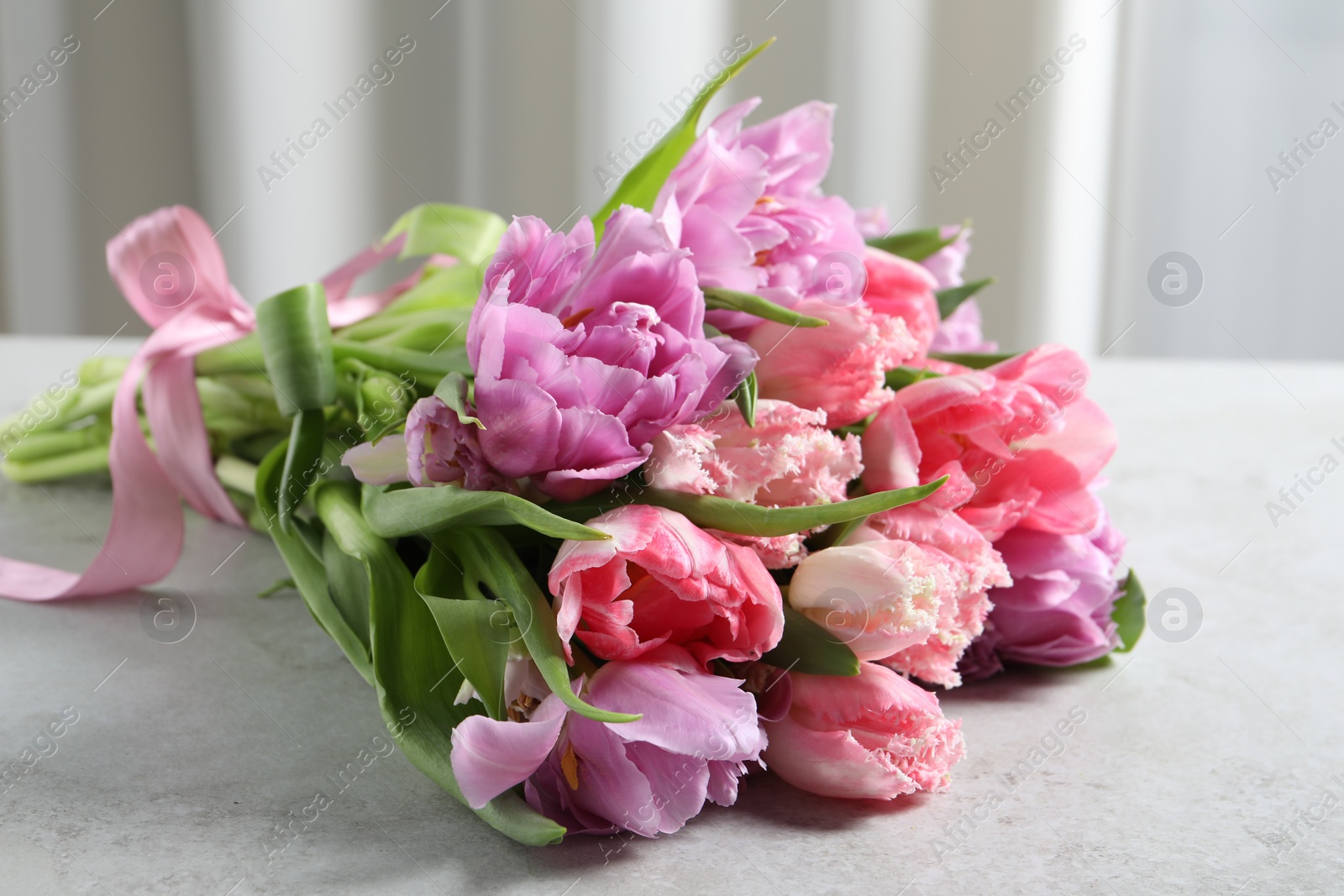 Photo of Beautiful bouquet of colorful tulip flowers on light gray table