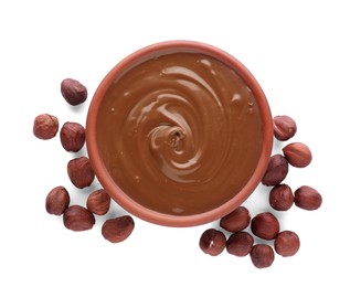 Bowl with delicious chocolate paste and hazelnuts on white background, top view