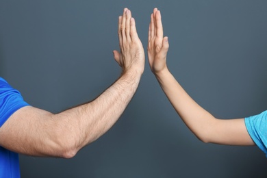 Photo of Man and woman giving high five on color background