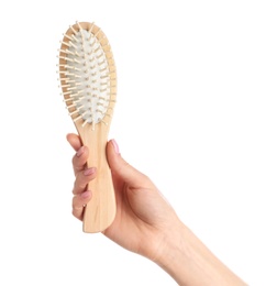 Photo of Woman holding wooden hair brush against white background, closeup