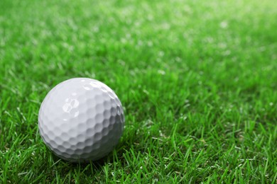 Photo of Golf ball on green grass, space for text