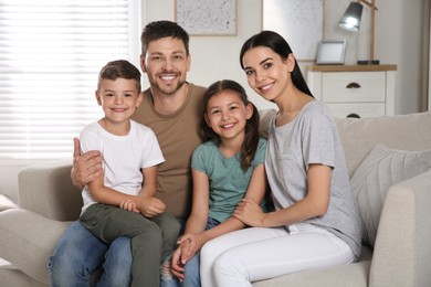 Portrait of happy family in living room. Adoption concept