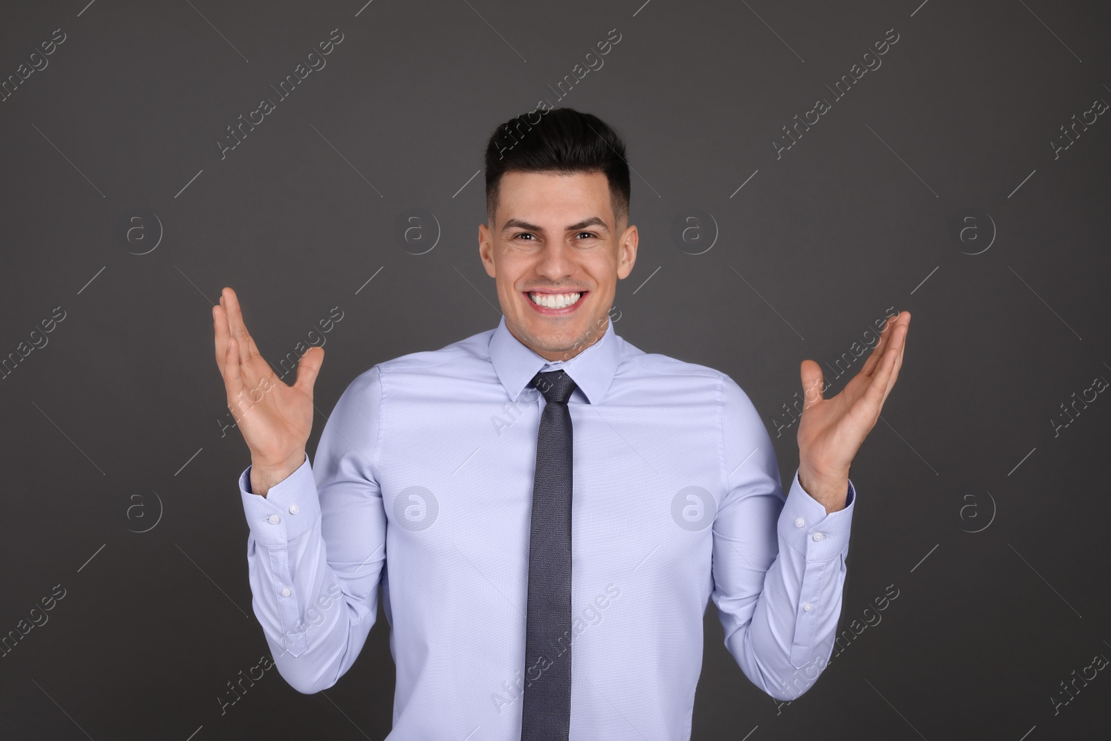 Photo of Portrait of happy businessman on dark grey background. Personality concept