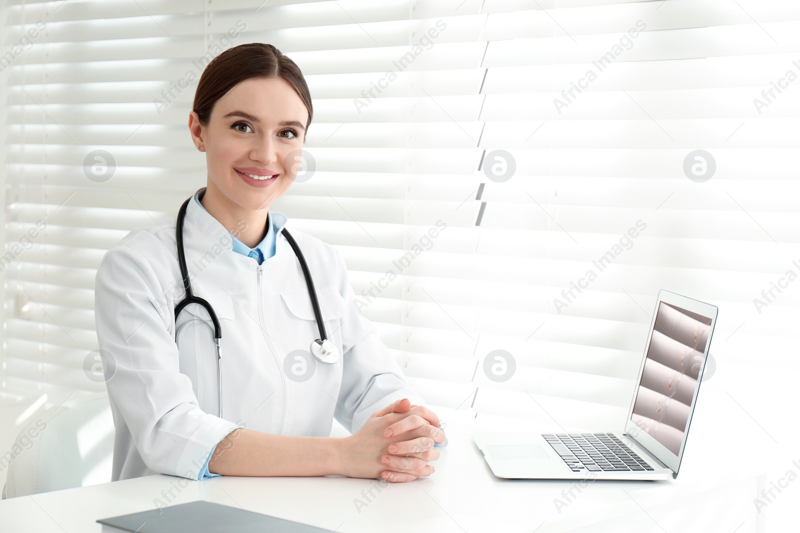 Photo of Portrait of young female doctor in white coat at workplace