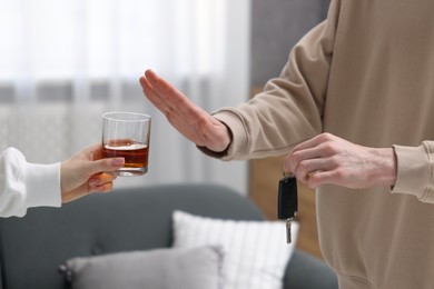 Photo of Driver with car keys refusing alcohol, closeup. Don't drink and drive concept