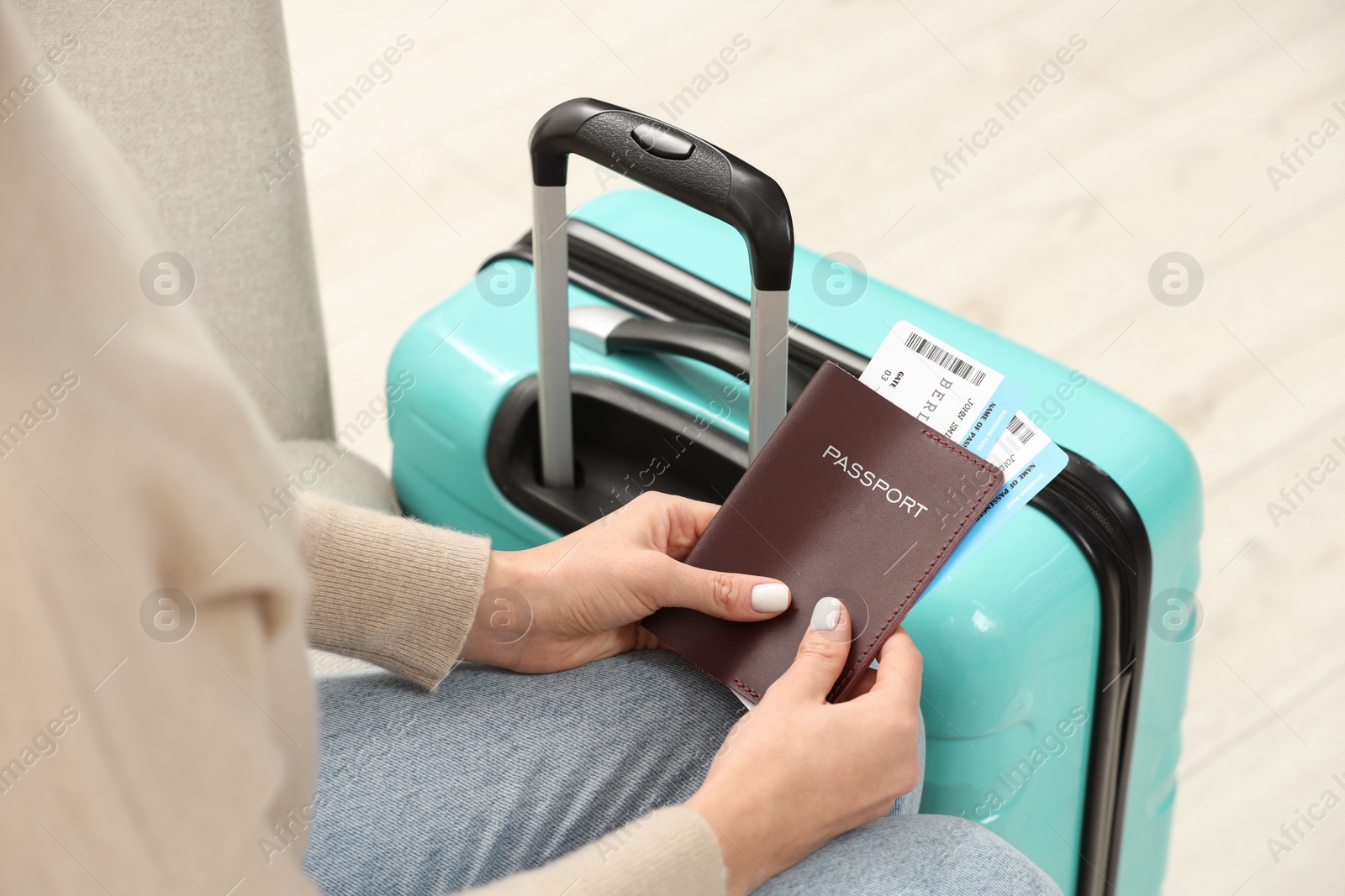 Photo of Woman with suitcase, passport and tickets on blurred background, closeup