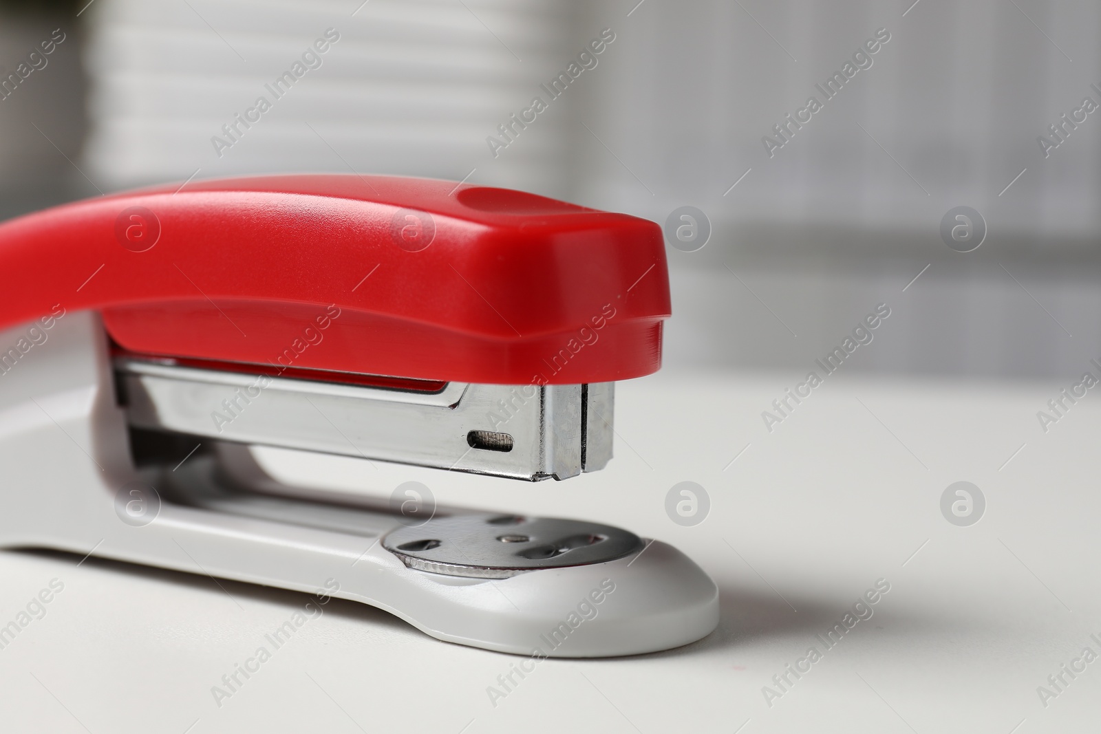 Photo of One stapler on white table, closeup. Space for text