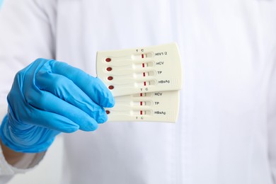 Photo of Doctor holding two disposable express tests for hepatitis, closeup