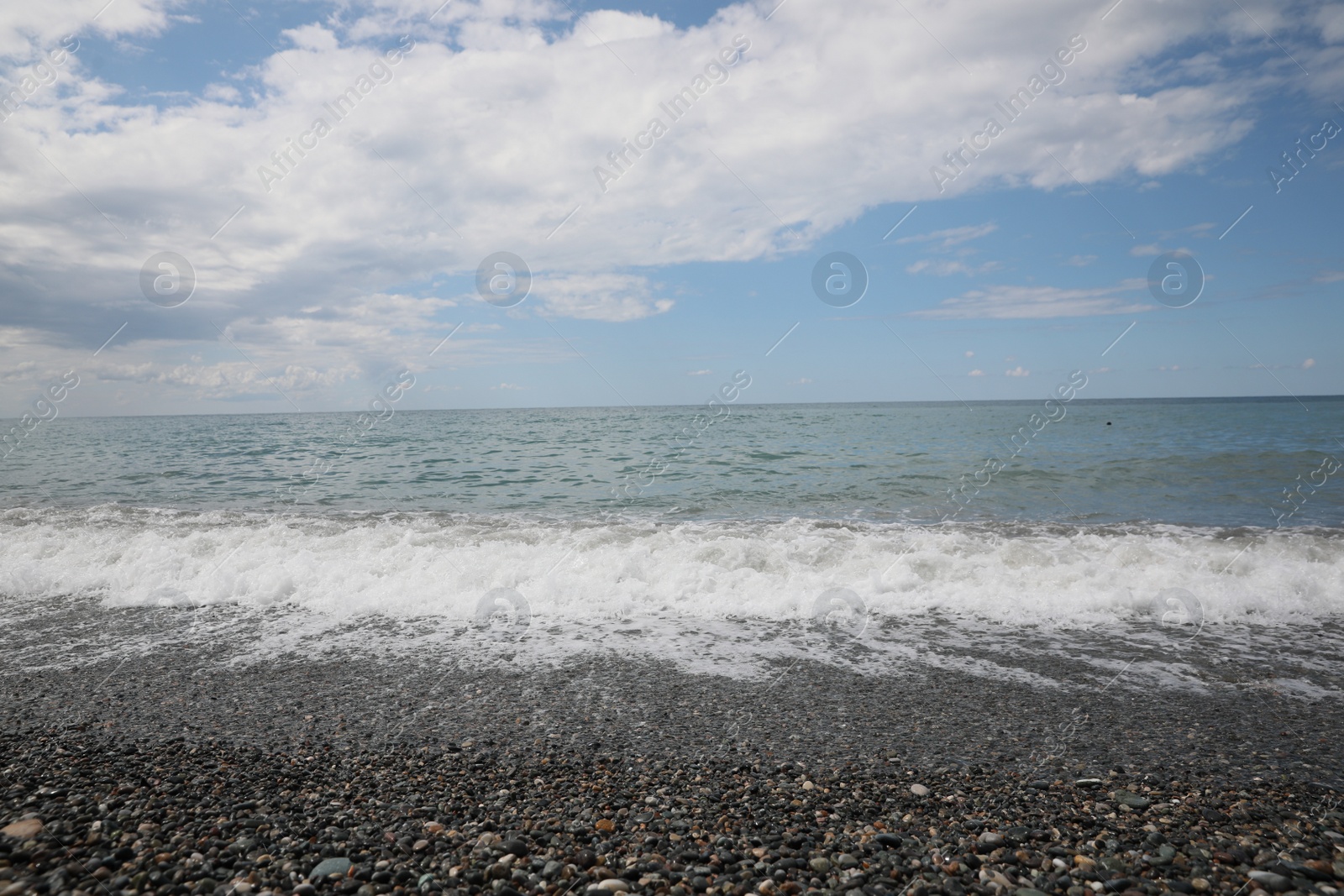 Photo of Picturesque view of beautiful sea shore under sky with fluffy clouds