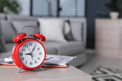 Photo of Alarm clock on table in living room. Time of day