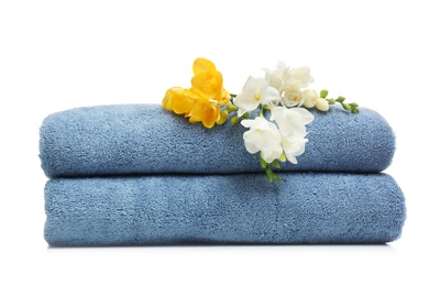 Clean folded towels with flowers on white background