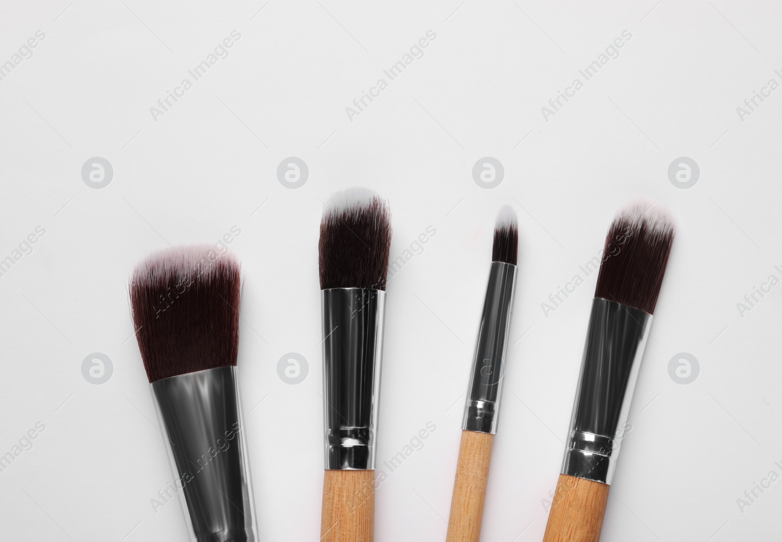 Photo of Set of makeup brushes on white background, flat lay. Space for text