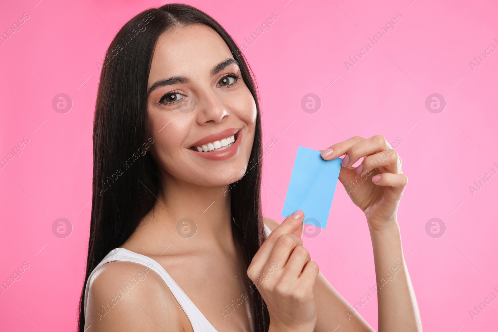 Photo of Beautiful woman with mattifying wipe on pink background