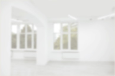 Image of Empty room with white wall and windows, blurred view
