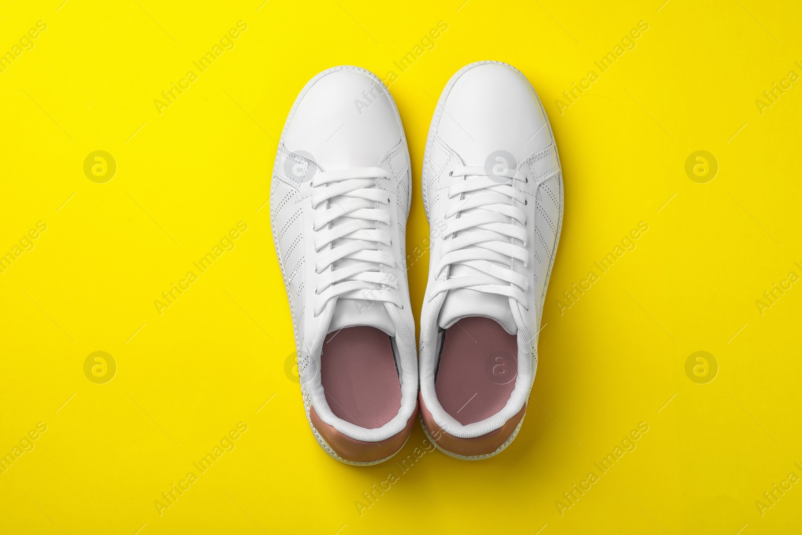 Photo of Pair of sneakers on color background, flat lay