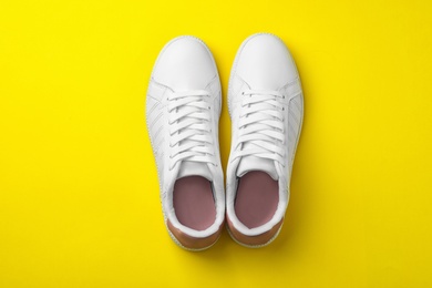 Photo of Pair of sneakers on color background, flat lay