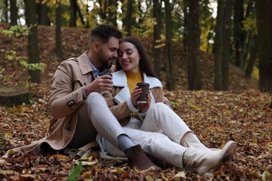 Happy young couple spending time together in autumn park