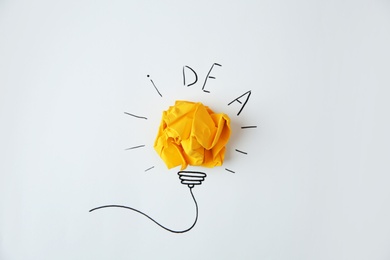 Photo of Composition with crumpled paper as lamp bulb and word IDEA on white background