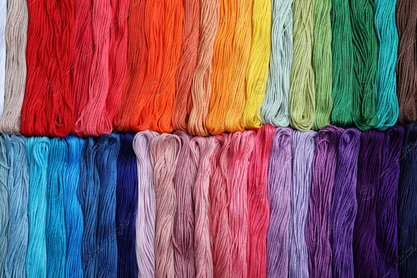 Photo of Different colorful embroidery threads as background, top view