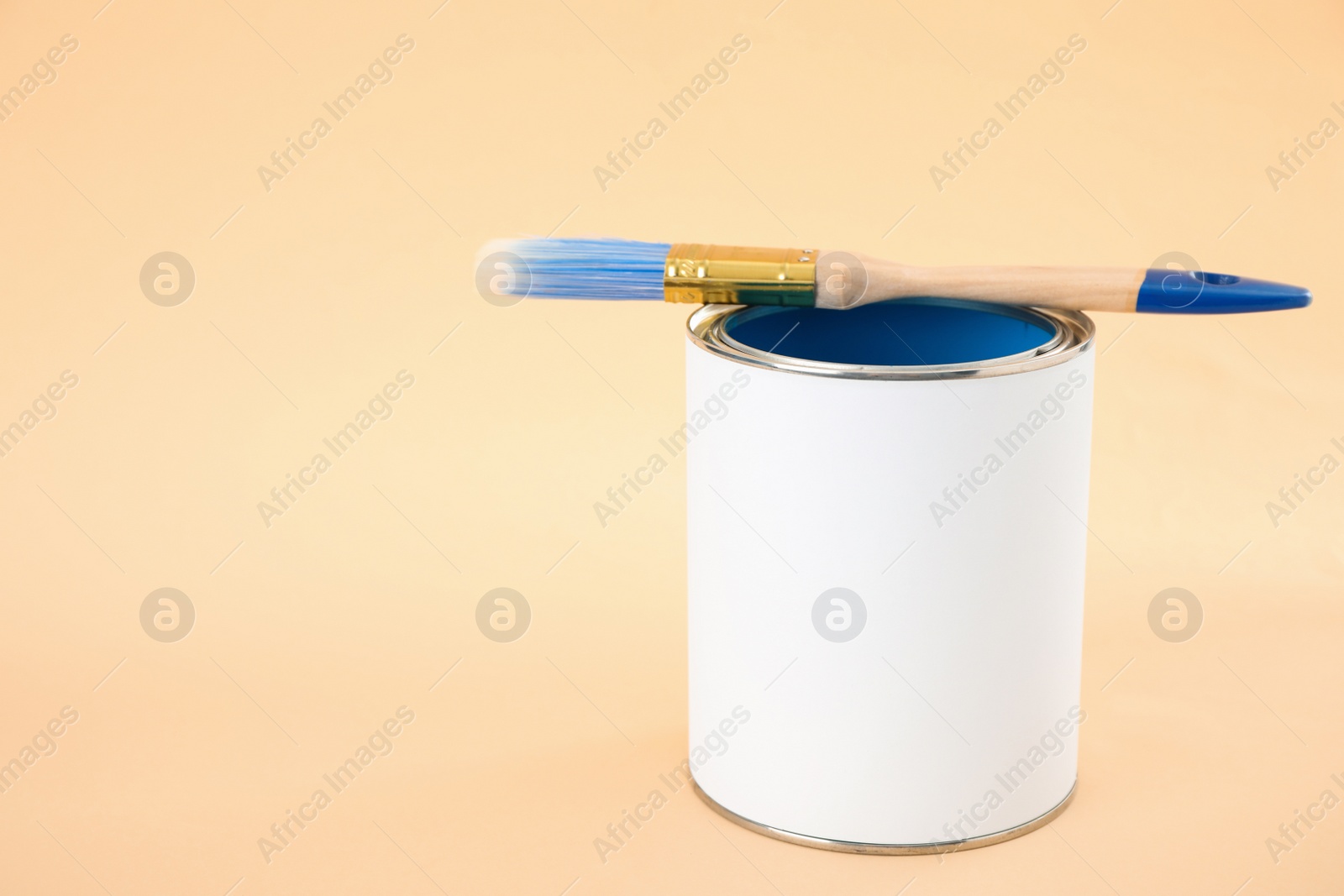 Photo of Open blank can of paint with brush on color background. Space for text