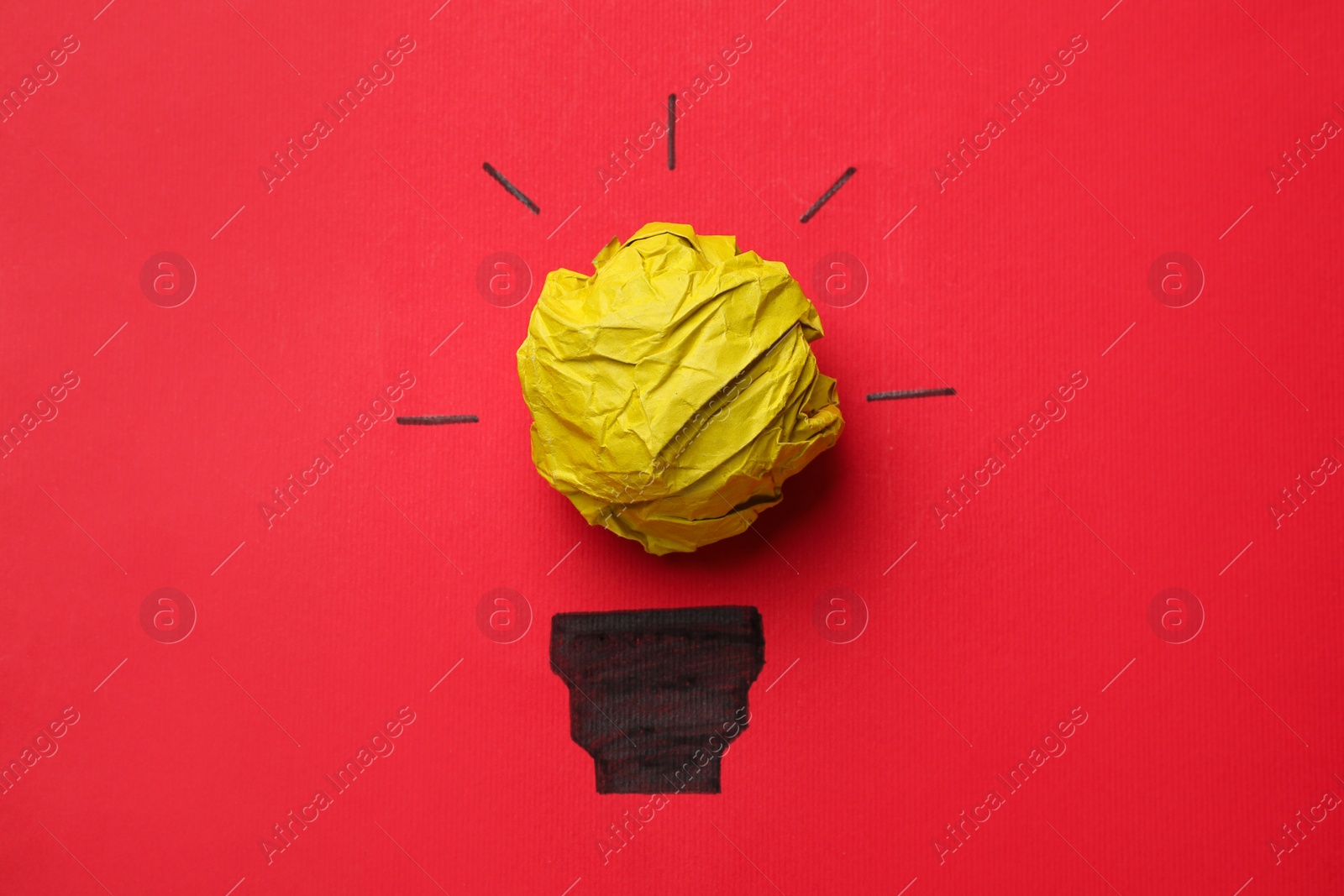 Photo of Idea concept. Light bulb made with crumpled paper and drawing on red background, top view