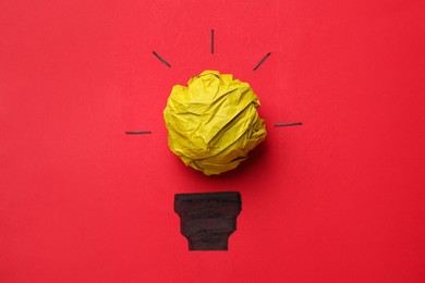 Photo of Idea concept. Light bulb made with crumpled paper and drawing on red background, top view