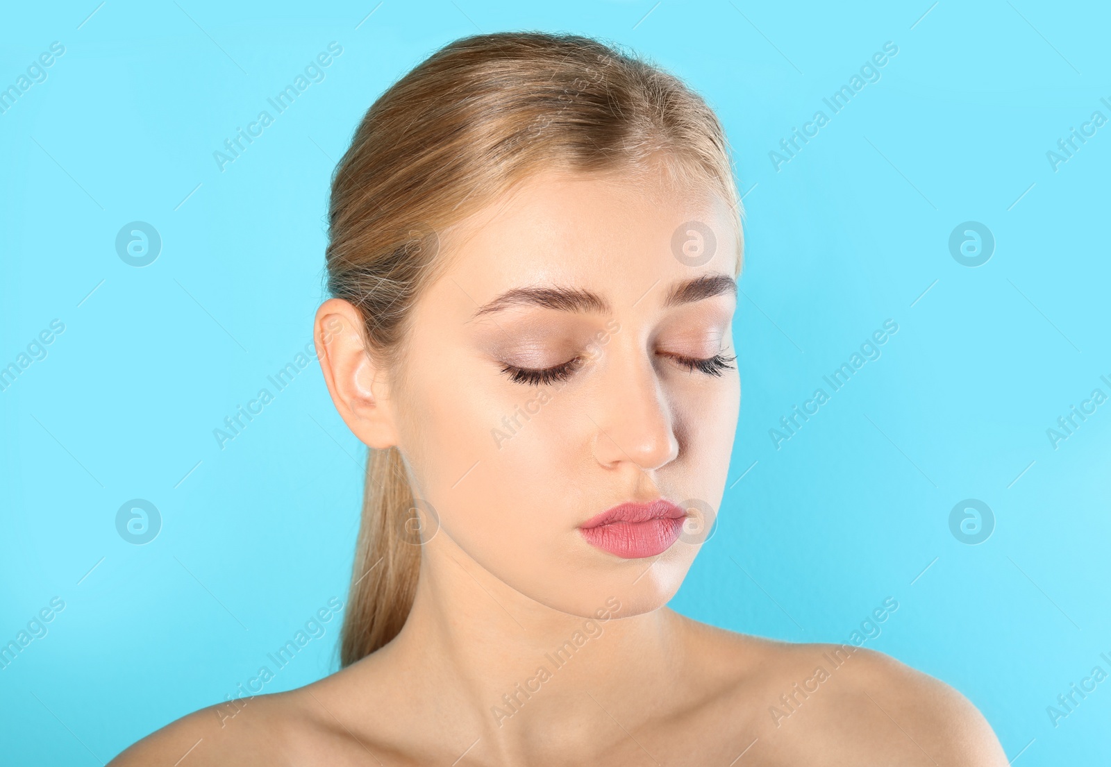 Photo of Portrait of young woman with beautiful natural eyelashes on color background
