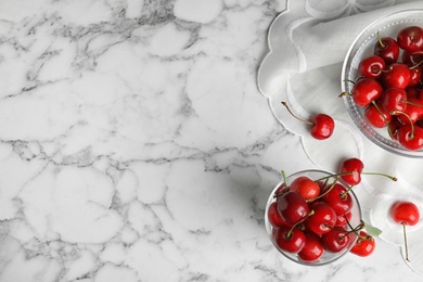 Flat lay composition with sweet cherries on marble table. Space for text