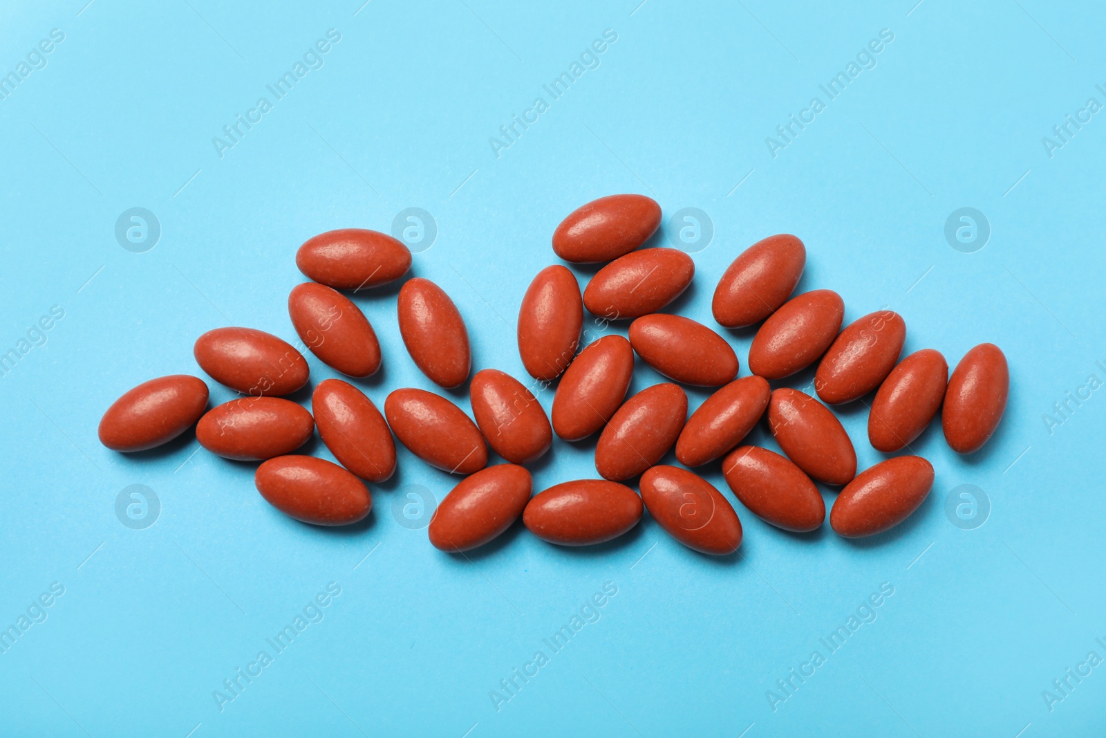 Photo of Heap of pills on turquoise background, flat lay. Anemia treatment