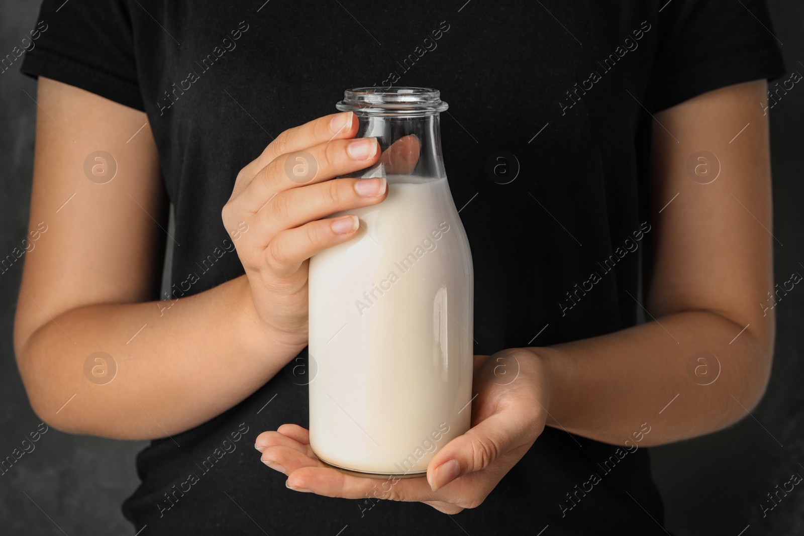 Photo of Woman holding bottle of hemp milk, closeup