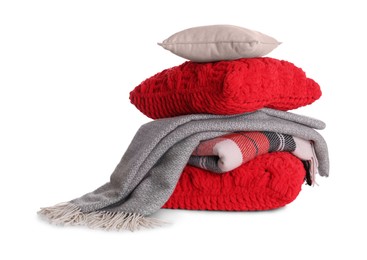 Stack of pillows and folded warm plaids on white background