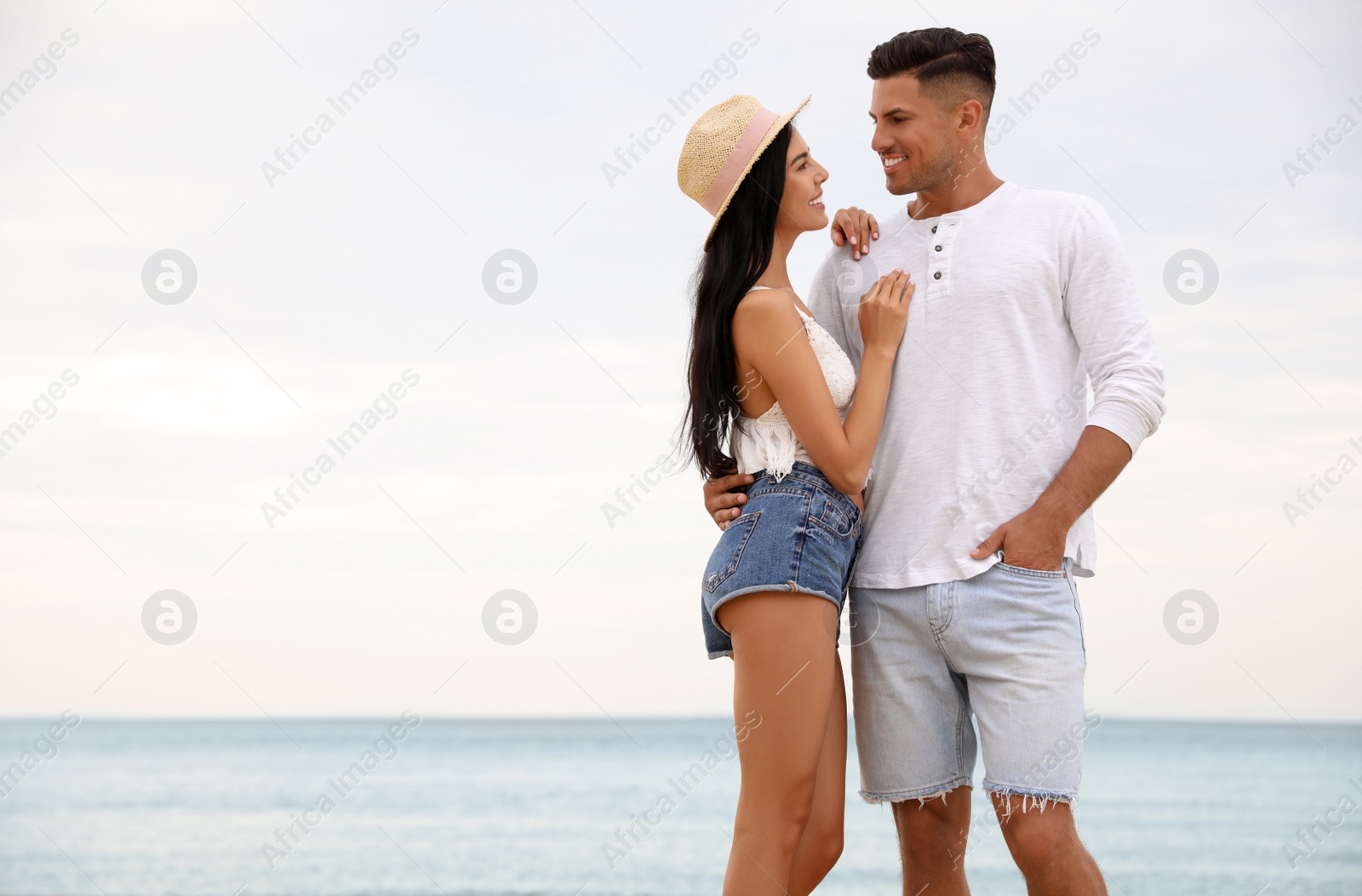 Photo of Lovely couple spending time together on beach. Space for text