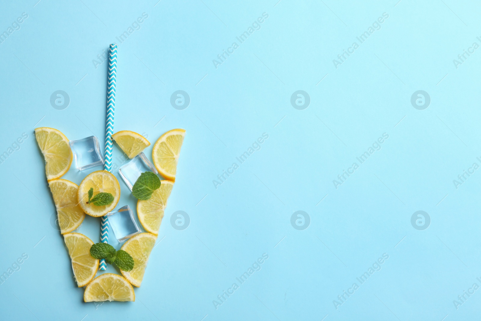 Photo of Creative lemonade layout with lemon slices, mint and ice on light blue background, top view. Space for text