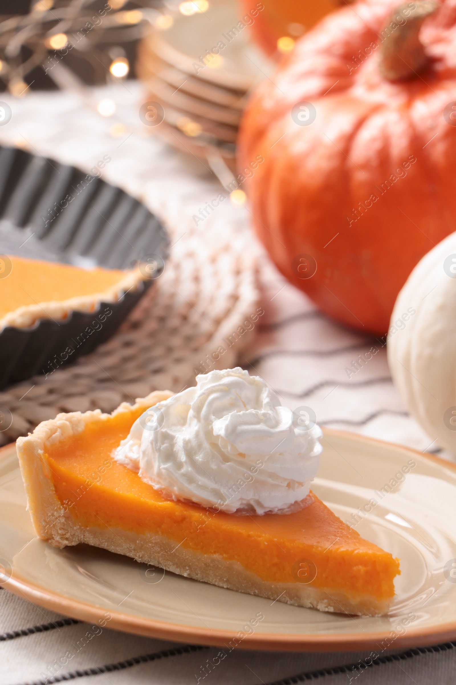 Photo of Piece of fresh homemade pumpkin pie with whipped cream on table