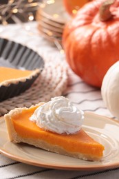 Photo of Piece of fresh homemade pumpkin pie with whipped cream on table