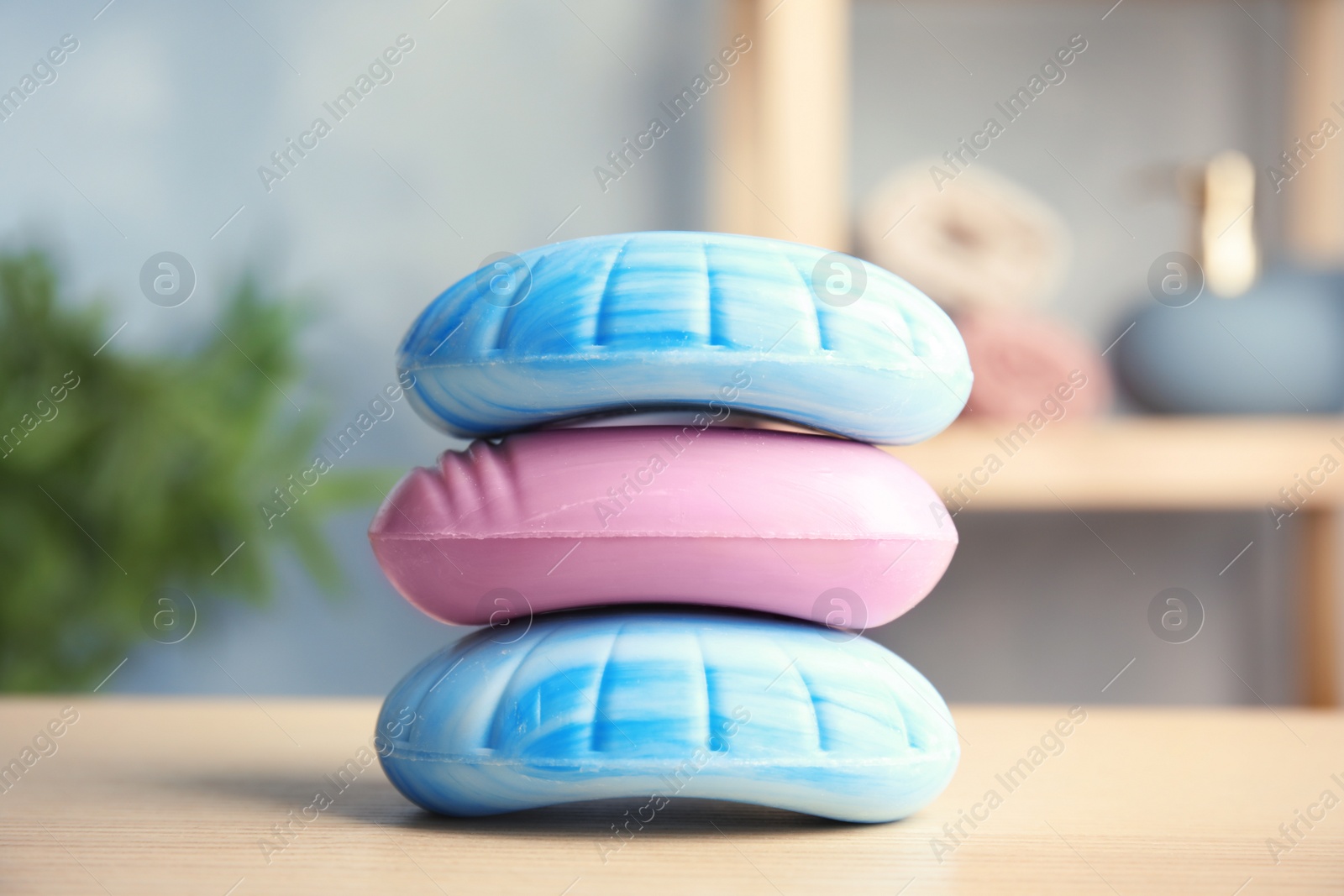 Photo of Different stacked soap bars on table in bathroom
