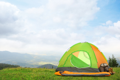Image of Camping tent with sleeping bag and boots outdoors