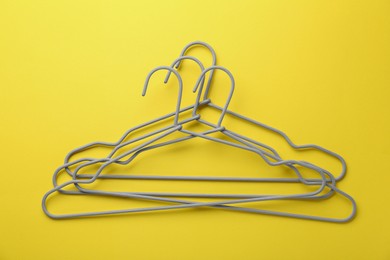 Many hangers on yellow background, top view