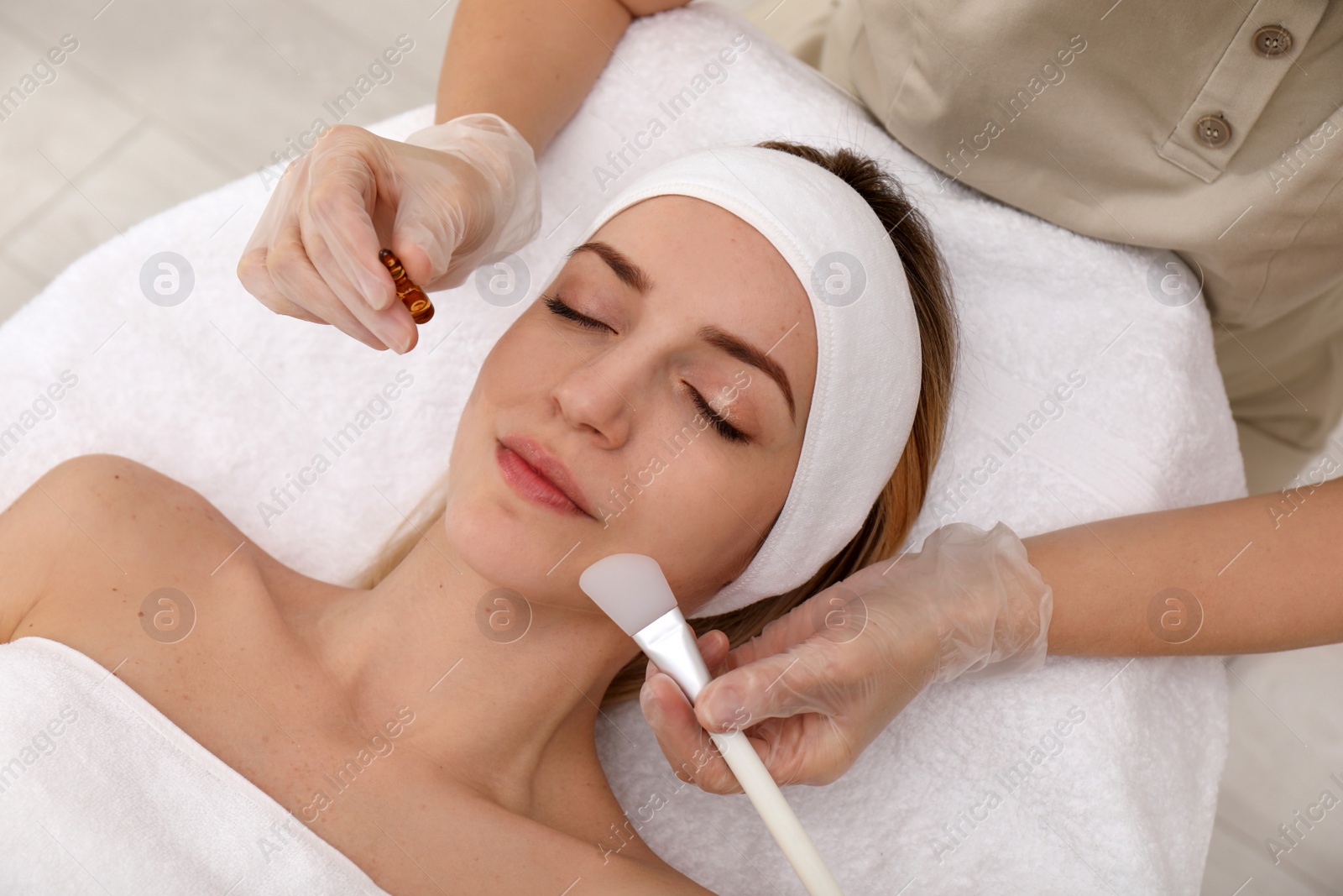 Photo of Young woman during face peeling procedure in salon