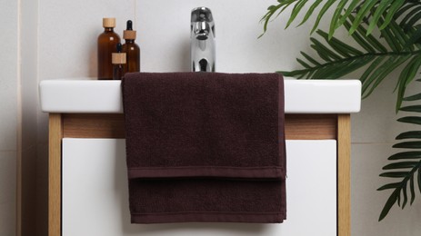 Photo of Brown soft towel on sink in bathroom