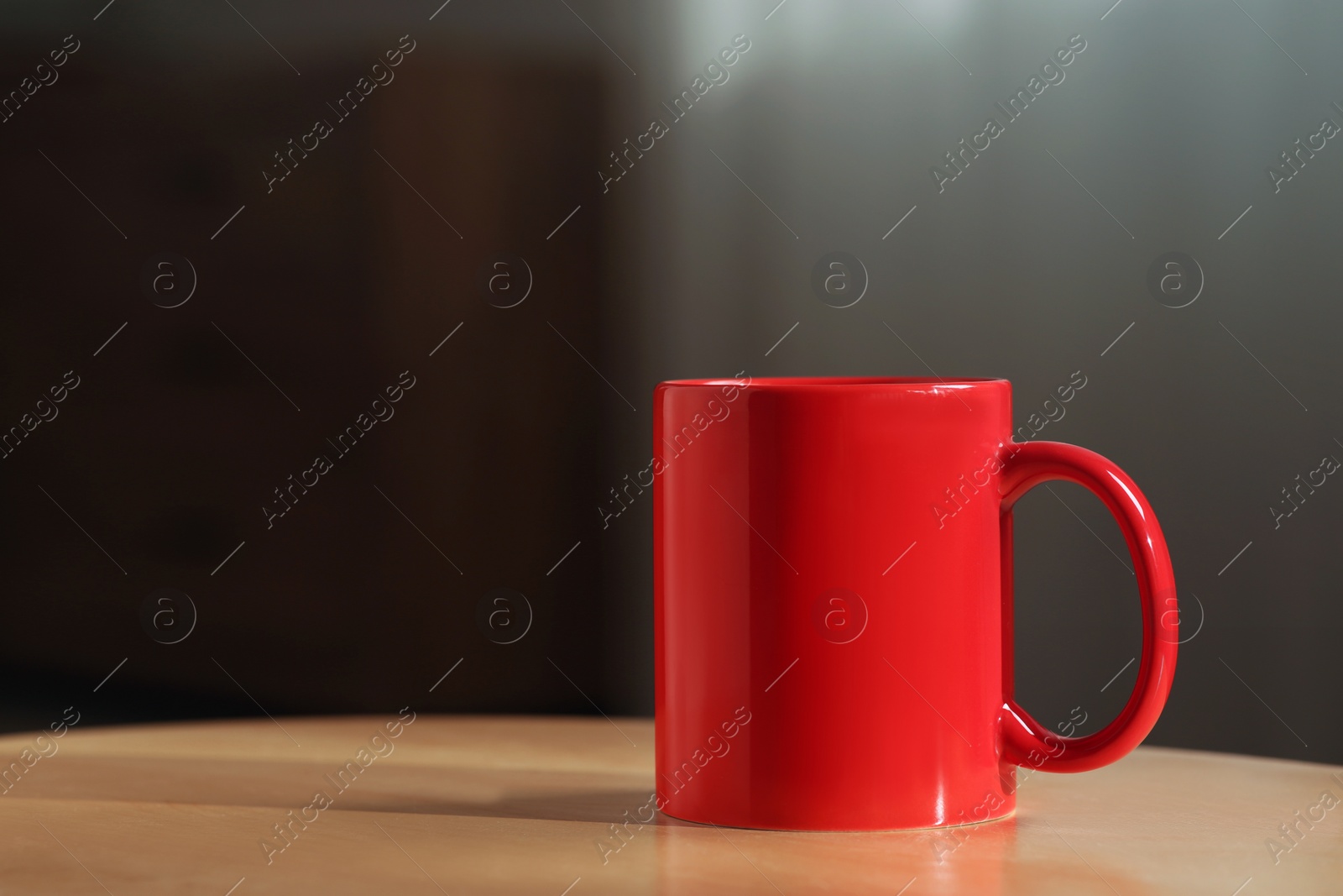 Photo of Red mug on wooden table indoors. Mockup for design